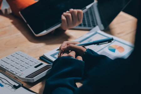 Businesswoman or accountant working Financial investment on calculator, calculate, analyze business and marketing growth on financial document data graph, Accounting, Economic, commercial concept.の写真素材