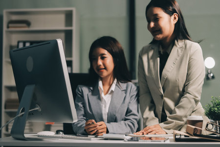 Asian Businesswoman Using laptop computer and working at office with calculator document on desk, doing planning analyzing the financial report, business plan investment, finance analysis concept.の写真素材