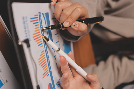 Group of confident business people point to graphs and charts to analyze market data, balance sheet,...