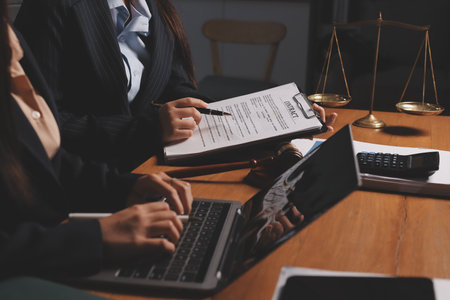 Attractive young lawyer in office Business woman and lawyers discussing contract papers with brass scale on wooden desk in office. Law, legal services, advice, Justice and real estate concept.の写真素材