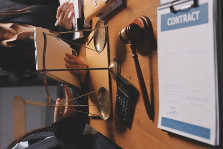 Attractive young lawyer in office Business woman and lawyers discussing contract papers with brass scale on wooden desk in office. Law, legal services, advice, Justice and real estate concept.の写真素材
