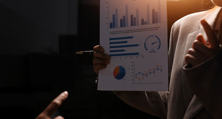 Group of confident business people point to graphs and charts to analyze market data, balance sheet,...