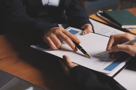 Business woman and lawyers discussing contract papers with brass scale on wooden desk in office. Law, legal services, advice, Justice and real estate concept.の写真素材
