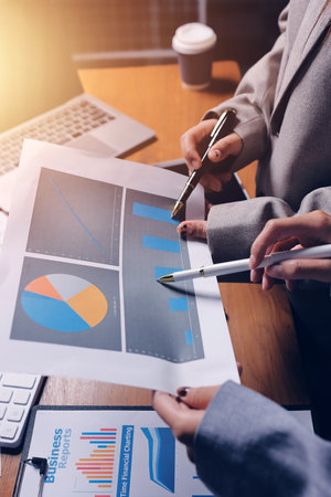 Group of confident business people point to graphs and charts to analyze market data, balance sheet,...