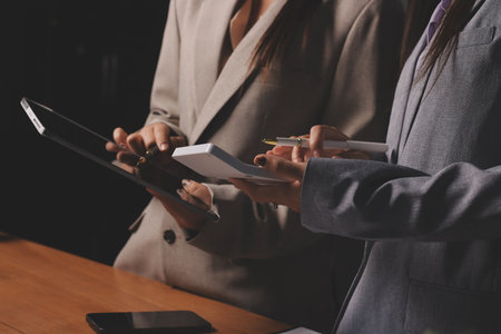 Group of confident business people point to graphs and charts to analyze market data, balance sheet, account, net profit to plan new sales strategies to increase production capacity.の写真素材