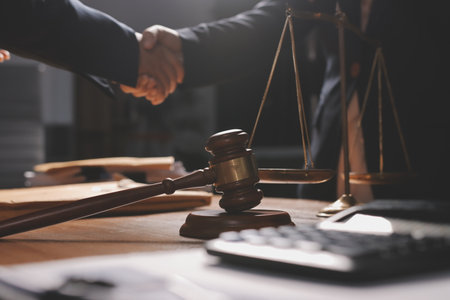 Young lawyer in office. Business woman and lawyers discussing contract papers with brass scale on wooden desk in office. Law, legal services, advice, Justice and real estate concept.の写真素材