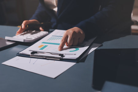 Expert woman asian female people review data number costing managerial account prepare monthly actual cost variance report at tax audit office. ESG sheet budget control ERP process service project.の写真素材