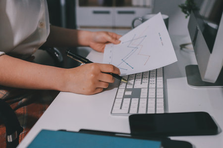 Expert woman asian female people review data number costing managerial account prepare monthly actual cost variance report at tax audit office. ESG sheet budget control ERP process service project.の写真素材