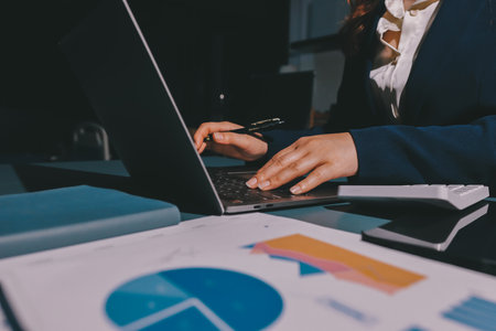 Expert woman asian female people review data number costing managerial account prepare monthly actual cost variance report at tax audit office. ESG sheet budget control ERP process service project.の写真素材