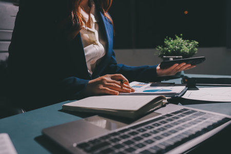 Expert woman asian female people review data number costing managerial account prepare monthly actual cost variance report at tax audit office. ESG sheet budget control ERP process service project.の写真素材