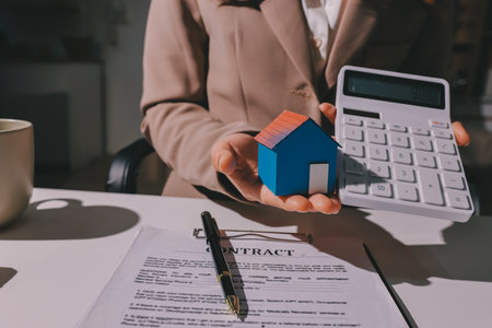 Female Real Estate Broker presenting and advised to 
model home and building project detail in the office, sign purchase sales contract, agreements concerned mortgage loan offer and insurance.の写真素材