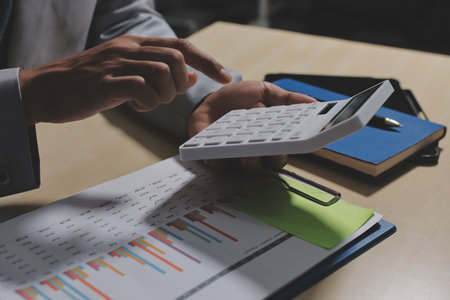 Working from home, Closeup business woman using laptop computer and analyzing financial report.の写真素材