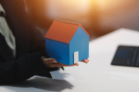 Real estate agents explain models of housing estates in projects to elaborate to clients, explaining and presenting information about homes and purchasing loans. Real estate trading concept.の写真素材