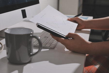 Expert woman asian female people review data number costing managerial account prepare monthly actual cost variance report at tax audit office. ESG sheet budget control ERP process service project.の写真素材