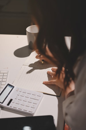 Expert woman asian female people review data number costing managerial account prepare monthly actual cost variance report at tax audit office. ESG sheet budget control ERP process service project.の写真素材