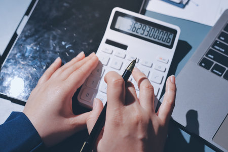 Expert woman asian female people review data number costing managerial account prepare monthly actual cost variance report at tax audit office. ESG sheet budget control ERP process service project.の写真素材