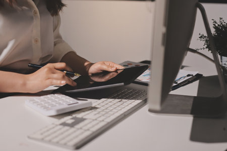 Expert woman asian female people review data number costing managerial account prepare monthly actual cost variance report at tax audit office. ESG sheet budget control ERP process service project.の写真素材