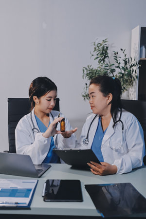 Male and female doctors are having a meeting in a hospital room.の写真素材