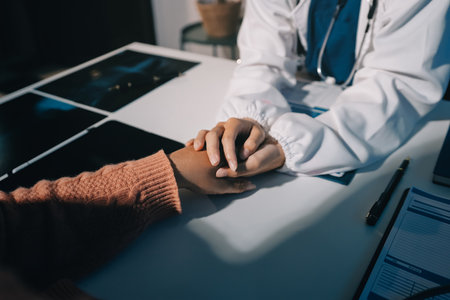 Asian female hands touching old female hand in a hospital setting.の写真素材