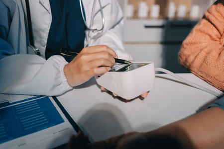 Nurse measuring blood pressure of elderly woman at table, closeup. Assisting senior generationの写真素材