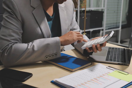 Working from home, Closeup business woman using laptop computer and analyzing financial report.の写真素材