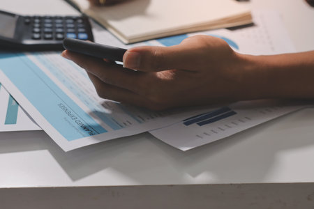 Working from home, Closeup business woman using laptop computer and analyzing financial report.の写真素材