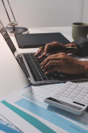 Working from home, Closeup business woman using laptop computer and analyzing financial report.の写真素材
