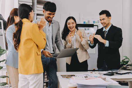 Group of Young Asian business team creative businesspeople coworker in office Happy to be successful partnership teamwork celebrating achievement and success concept.の写真素材