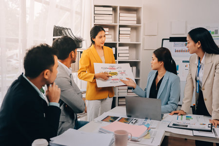 Team of financial advisory services. Asian advisor showing plan of investment to clients in the consultancy office.の写真素材