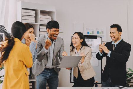 Group of Young Asian business team creative businesspeople coworker in office Happy to be successful partnership teamwork celebrating achievement and success concept.の写真素材