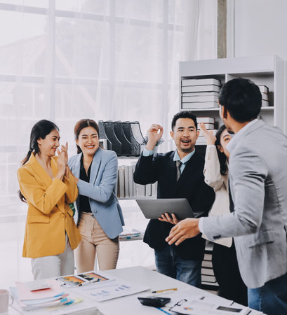 Group of Young Asian business team creative businesspeople coworker in office Happy to be successful partnership teamwork celebrating achievement and success concept.の写真素材