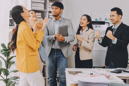 Group of Young Asian business team creative businesspeople coworker in office Happy to be successful partnership teamwork celebrating achievement and success concept.の写真素材