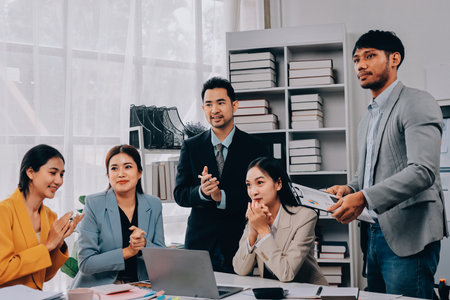 Group of Young Asian business team creative businesspeople coworker in office Happy to be successful partnership teamwork celebrating achievement and success concept.の写真素材
