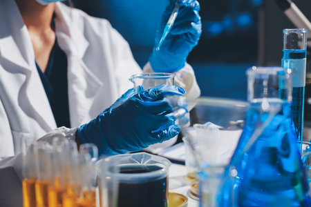 Scientist pipetting medical samples into microplate in laboratory