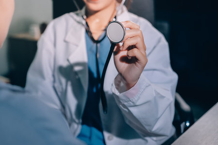 Cropped image of male doctor's hand using stethoscope to examining heartbeat and symptom of patient...
