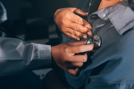 Cropped image of male doctor's hand using stethoscope to examining heartbeat and symptom of patient while talkingの写真素材