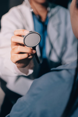 Cropped image of male doctor's hand using stethoscope to examining heartbeat and symptom of patient while talkingの写真素材