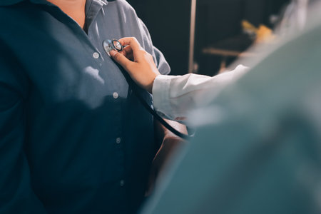 Cropped image of male doctor's hand using stethoscope to examining heartbeat and symptom of patient while talkingの写真素材