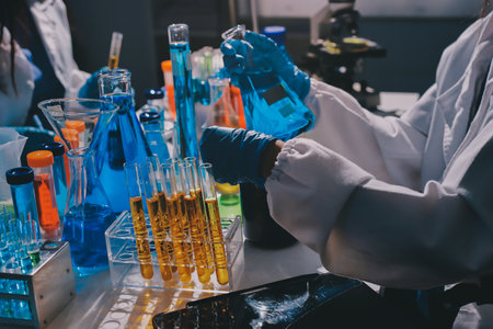 Scientist pipetting medical samples into microplate in laboratory