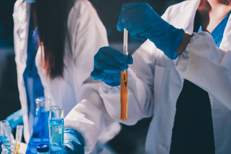 Scientist pipetting medical samples into microplate in laboratory