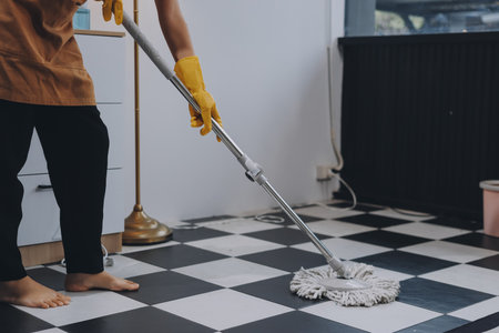 Female janitor with vacuum cleaner in room