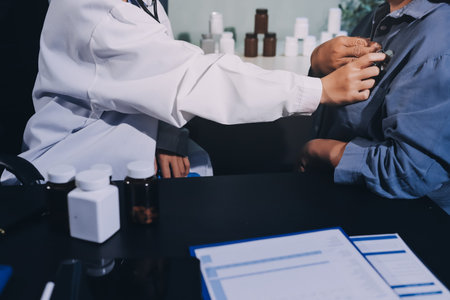 Cropped image of male doctor's hand using stethoscope to examining heartbeat and symptom of patient while talkingの写真素材
