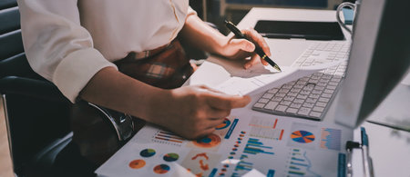 Expert woman asian female people review data number costing managerial account prepare monthly actual cost variance report at tax audit office. ESG sheet budget control ERP process service project.の写真素材