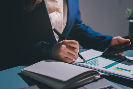 Expert woman asian female people review data number costing managerial account prepare monthly actual cost variance report at tax audit office. ESG sheet budget control ERP process service project.の写真素材