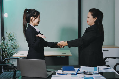 Businesspeople or lawyers shaking hands finishing up meeting or negotiation in sunny office. Business handshake and partnershipの写真素材