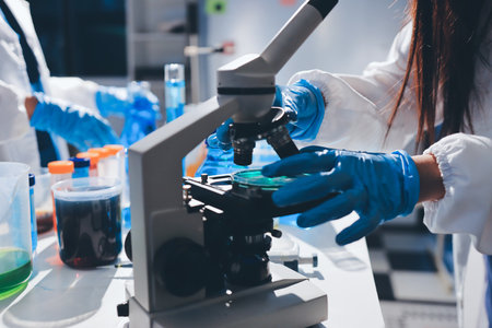 Scientist pipetting medical samples into microplate in laboratory