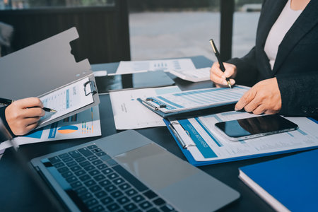 Teamwork with business people analysis cost graph on desk at meeting room. double exposure successful teamwork,business planning concept.の写真素材