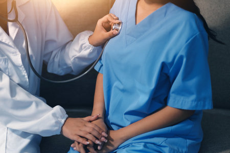 Close-up of doctor listening to a senior woman's heartbeatの写真素材