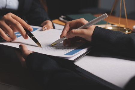 Attractive young lawyer in office Business woman and lawyers discussing contract papers with brass...