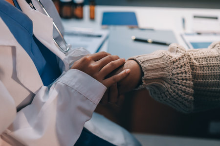 Medicine doctor hand reassuring her female patientの写真素材